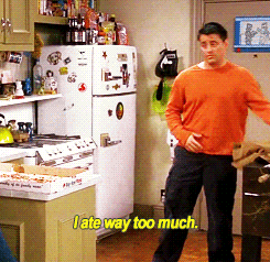 A gif of a guy holding his stomach saying "I ate way too much"