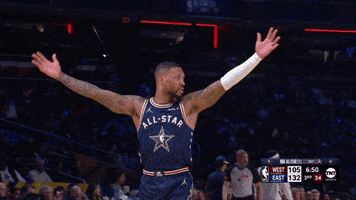 Sports gif. Damian Lillard of the Milwaukee Bucks raises his hands in the air in celebration and walks around the court with his hands outstretched.
