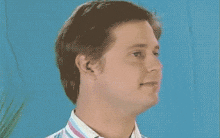 TV gif. Tim Heidecker from Tim and Eric looks forward, smiles awkwardly, and shrugs his shoulders.