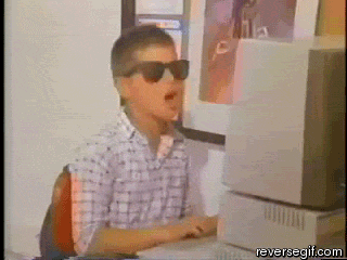 Short video loop of a kid sitting at a computer and putting on sun glasses