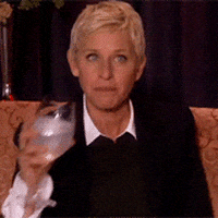 Celebrity gif. Ellen Degeneres spits water out of her mouth and gives a shocked expression with wide eyes. 
