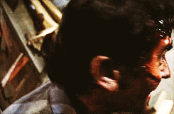 Movie gif. Bruce Campbell as Ash in The Evil Dead turns his face toward us to reveal a manic grin. He begins laughing evilly.