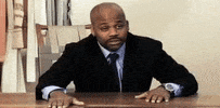 Celebrity gif. Steve Stoute leans over a table and flips his hands up, dejected, then bows his head down onto the desk.