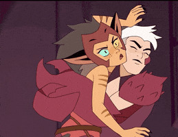 Cartoon gif. Catra on She-Ra and the Princesses of Power struggles to break free from the grip of Scorpia who has her claws around Catra in a bear hug. Catra is angry, but Scorpia looks amused as Catra shoves a Scorpio's face and then tugs at her claws uselessly.