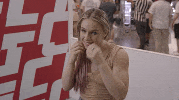 Sports gif. Vanessa Demopoulos from UFC is wearing a dress and throwing jabs at the camera.