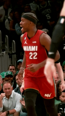 Sports gif. Slow motion clip of Jimmy Butler from the Miami Heat running down the court as he yells out in excitement, nodding his head with mouth open wide. 