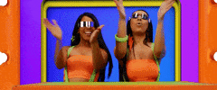 Music video gif. Rico Nasty and Doja Cat in the Tia Tamera Music video wear shiny sunglasses and matching outfits, clapping with their arms stretched out. Rico Nasty shakes her head and smiles with all her teeth showing.