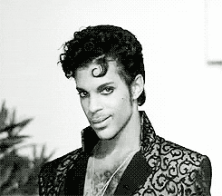 Celebrity gif. Prince looks at us with a seductive gaze. He slowly rubs his hand through the side of his head, smoothing out his hair. 