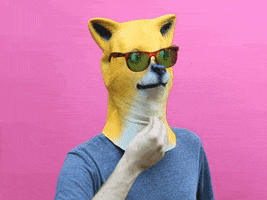 Video gif. Person wears a mask that looks like a Shibu Inu. The mask is looking to its side and wears sunglasses. The person strokes under the mask’s chin like they’re thinking hard.