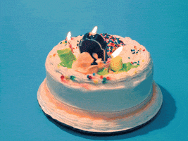 Video gif. Decorated birthday cake spins around, then stops as the candles burn out and reveal a central gravestone-shaped candle that says "you" stuck in front of a mound made of sprinkles.