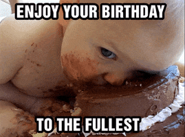 Video gif. A messy, naked baby smushes its face into a chocolate cake, one eye staring at us as it lazily consumes the cake without hands. Chocolate is smeared across its face and body. Text, "Enjoy your birthday to the fullest"