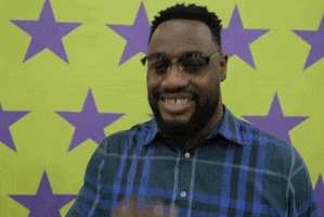 Sports gif. Leger Douzable of the New York Jets gives an encouraging smile and nods, pointing at us.