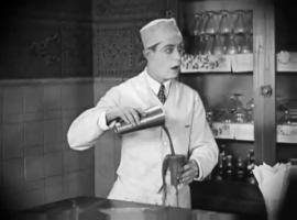 Movie gif. Soda jerk in old black and white movie pours a shake into an overflowing cup while looking stunned with his mouth gaping open.