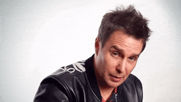 Celebrity gif. Sam Rockwell in a leather jacket sits and says, "That's awesome."