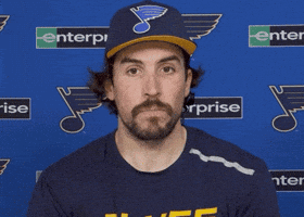 Sports gif. Justin Faulk of the St. Louis Blues hockey team sits for an interview. He considers what's being asked of him before saying, "Yep," clearly and boldly.