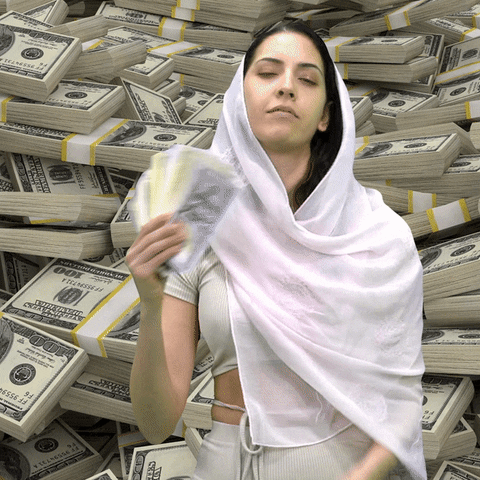 Video gif. Woman wearing a white hijab fans herself with a stack of money as she gazes at us knowingly in front of a background with bundles of cash.