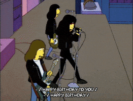 The Simpsons gif. The Ramones perform as Joey leans his microphone forward and points at us. Text, "Happy birthday to you. Happy birthday."