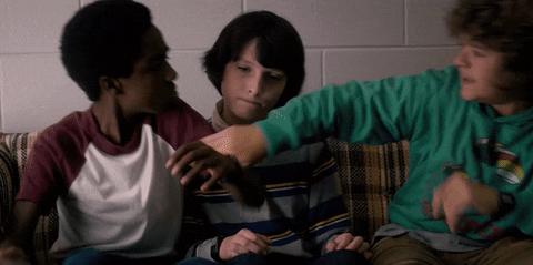 Stranger Things tv show gif, three male children sit on couch and have slap fight