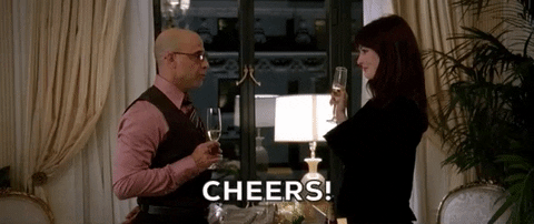 Andrea (Anne Hathaway) brindando con champaña