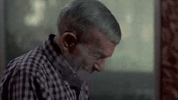 Movie gif. George Burns in Oh God You Devil, smiles, looking down, saying almost to himself, "I love to scare the hell out of people."
