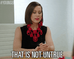 Celebrity gif. Miriam Shor seated at a desk looks down at her hand as she plays with an oversized black ring on her pinky finger and then regards the person seated across from her. Text, "That is not untrue."