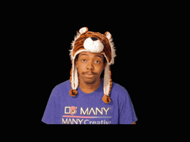 Video gif. A man wears a tiger beanie and shrugs as if uncertain. 