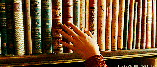 GIF: Liesel running her fingers over books in The Book Thief