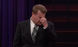 TV gif. An exasperated James Corden rubs his brow and face, clearly annoyed by something.