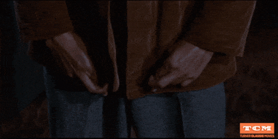 Movie gif. Sal Mineo as Plato in Rebel Without a Cause raises two crossed fingers to his chest as he nodes his head as if offering the best of luck. 