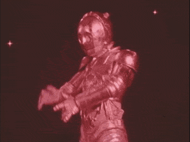 Video gif. C3PO dances jerkily before we cut to R2D2 gliding our way.