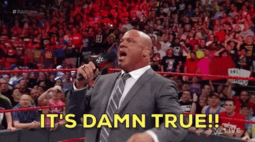 Sports gif. WWE pro-wrestler Kurt Angle stands center-ring in a business suit and says into his microphone "It's damn true!"