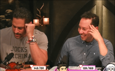From Critical Role: Man rubbing his face, eyes squinting in confusion as he attempts to answer a math-related problem in his head. The man next to him watches his struggle in glee and declares, "Maaaaaaath!"