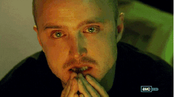 TV gif. Aaron Paul as Jesse in Breaking Bad. His eyes are brimmed with red, as if he hasn't slept for a while, and he puts his hands in prayer hands at his lips, contemplating.