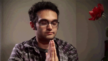 Video gif. Man closes his eyes with his hands in the prayer position in front of his chest. He peacefully prays until something disrupts him, and his eyes pop open. He looks at someone with a quizzical expression, shooting his eyebrow up in confusion.