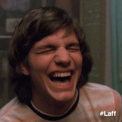 TV gif. Close up on Ashton Kutcher as Michael on That 70s Show. He is laughing hysterically, to the point where he’s rocking back and forth. 