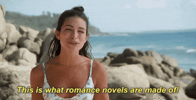 GIF. Woman on the beach saying, "This is what romance novels are made of."