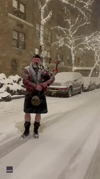 Bagpiper Performs 'Come All Ye Faithful' Illuminated by Manhattan's Christmas Lights