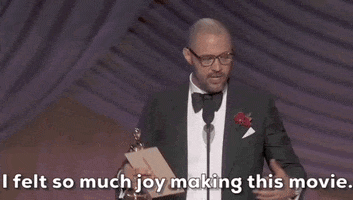 Oscars 2024 gif. Cord Jefferson, writer of American Fiction, gestures widely with his arms while holding his Oscars trophy and envelope in one hand. He says emphatically, "I felt so much joy making this movie." 