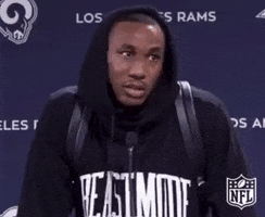 Sports gif. Marcus Peters from the LA Rams is being interviewed and he gives a big shrug of his shoulders and face scrunch while shaking his head.