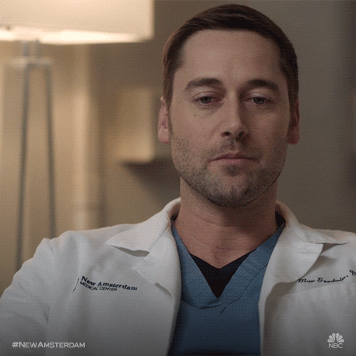 TV gif. Ryan Eggold as Dr Max Goodwin on New Amsterdam placidly winks at us and holds up an "ok" symbol with his hand.