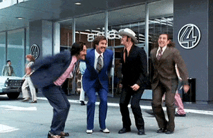 Movie gif. Anchorman movie characters Ron, Brian, Champ, and Brick all jump for joy together outside the Channel 4 News station. 