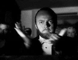 Movie gif. Orson Welles as Kane in Citizen Kane, looks extremely serious and claps vehemently.