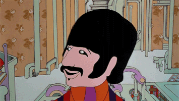 Cartoon gif. Ringo in The Yellow Submarine looks at us smiling, then transforms, his black hair and mustache turning gray and growing long and poofy.