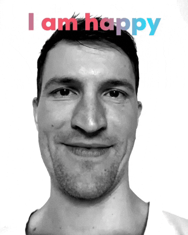 Video gif. A man gets up close to us with wide eyes and a gaping mouth. Text, "I am happy."