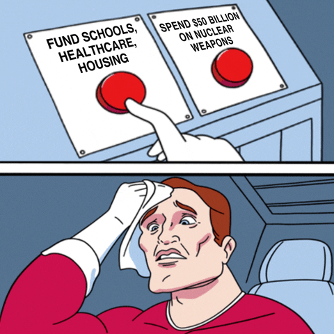 Meme gif. Daily Struggle sweats to choose between a button labeled "fund schools, healthcare, housing," and a button labeled "Spend 50 billion dollars on nuclear weapons."