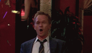 TV gif. Neil Patrick Harris as Barney in How I Met Your Mother. He sits up straight at the bar and confetti goes off and he claps his hands loudly while whooping.