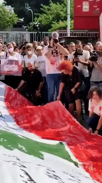 Protesters Hold Large Lebanese Flag on Anniversary of Deadly Beirut Explosion