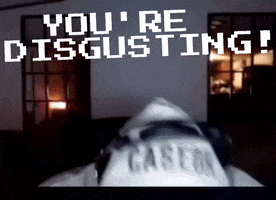 Video gif. A man wearing a hoodie and headphones lifts his head up from the table and yells, "You're disgusting!"