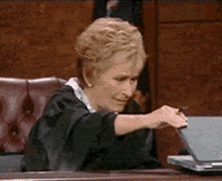 Reality TV gif. Judge Judy, sitting at the bench, opens a laptop cautiously. Disgusted at what she sees, she slowly closes the laptop.