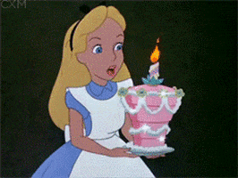 Cartoon gif. Alice from Alice from Wonderland holds a pink cake and she blows out the candle on top of it. Colorful sparkles buzz around the candle and then the cake shoots out of her hands like a firework would.